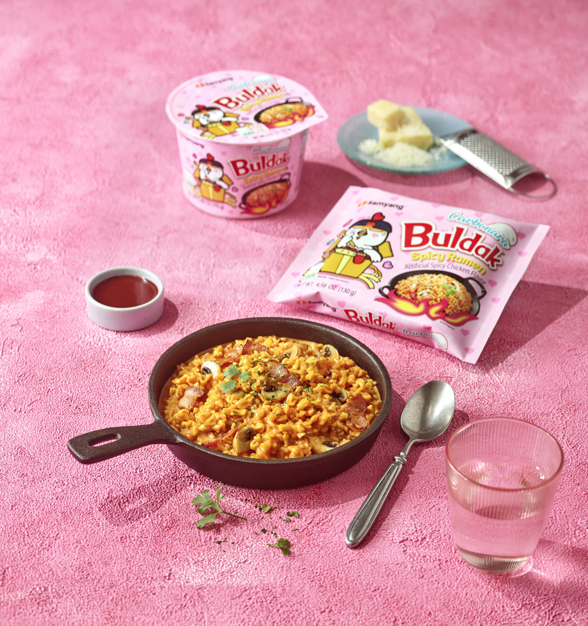 Buldak Carbonara preparada en un tazón junto a su paquete rosa
